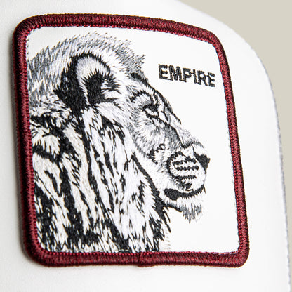 Courtside Empire by Goorin Bros.: a rectangular patch featuring a black and white embroidered lion head with a leather-look crown, "EMPIRE" in all caps, maroon border stitching, and white background—ideal for adding courtside or sneaker style.
