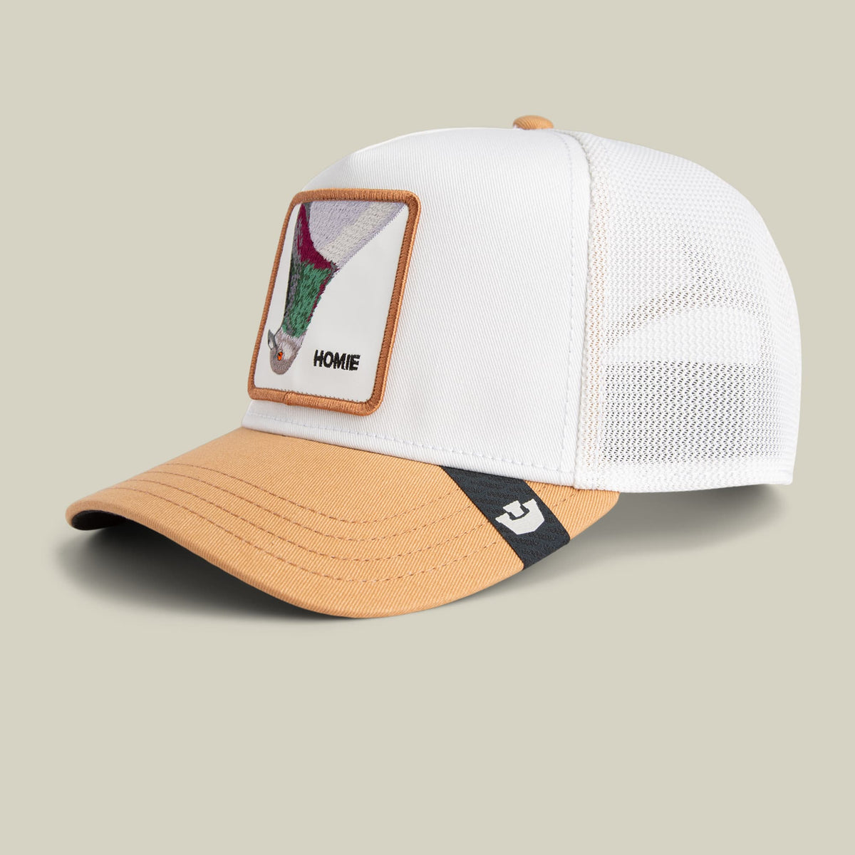 The Goorin Bros. Noegip trucker hat features a white mesh back, tan bill, and colorful patch detail on the front, displayed against a neutral background.