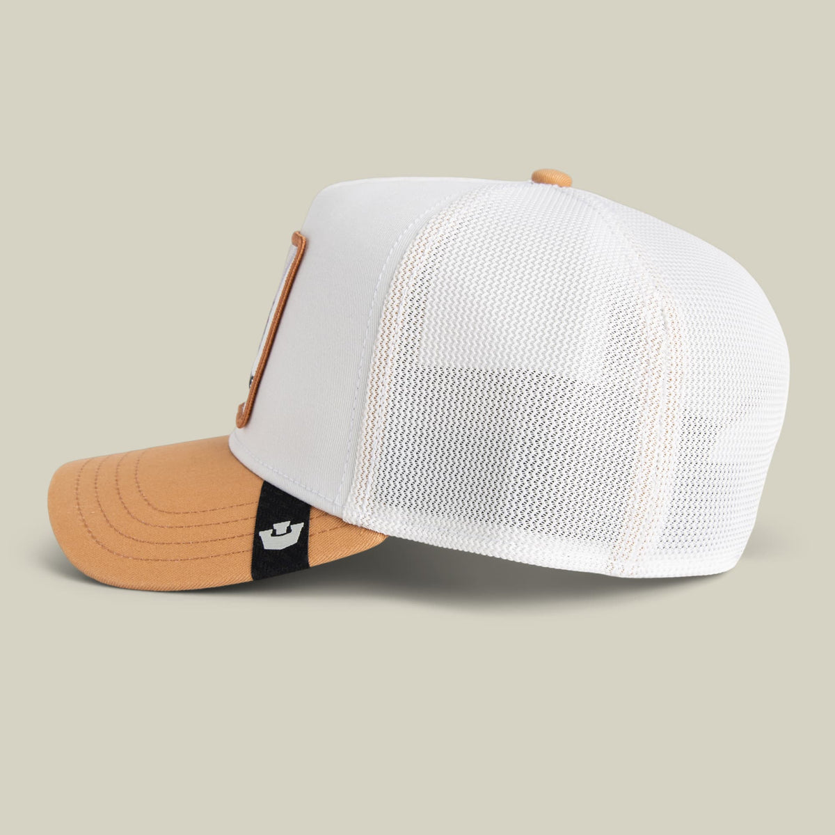The Goorin Bros. Noegip trucker hat features a white mesh back panel and tan cotton front with an orange bill, displayed on a neutral background with a small branded patch visible on the snapback closure.