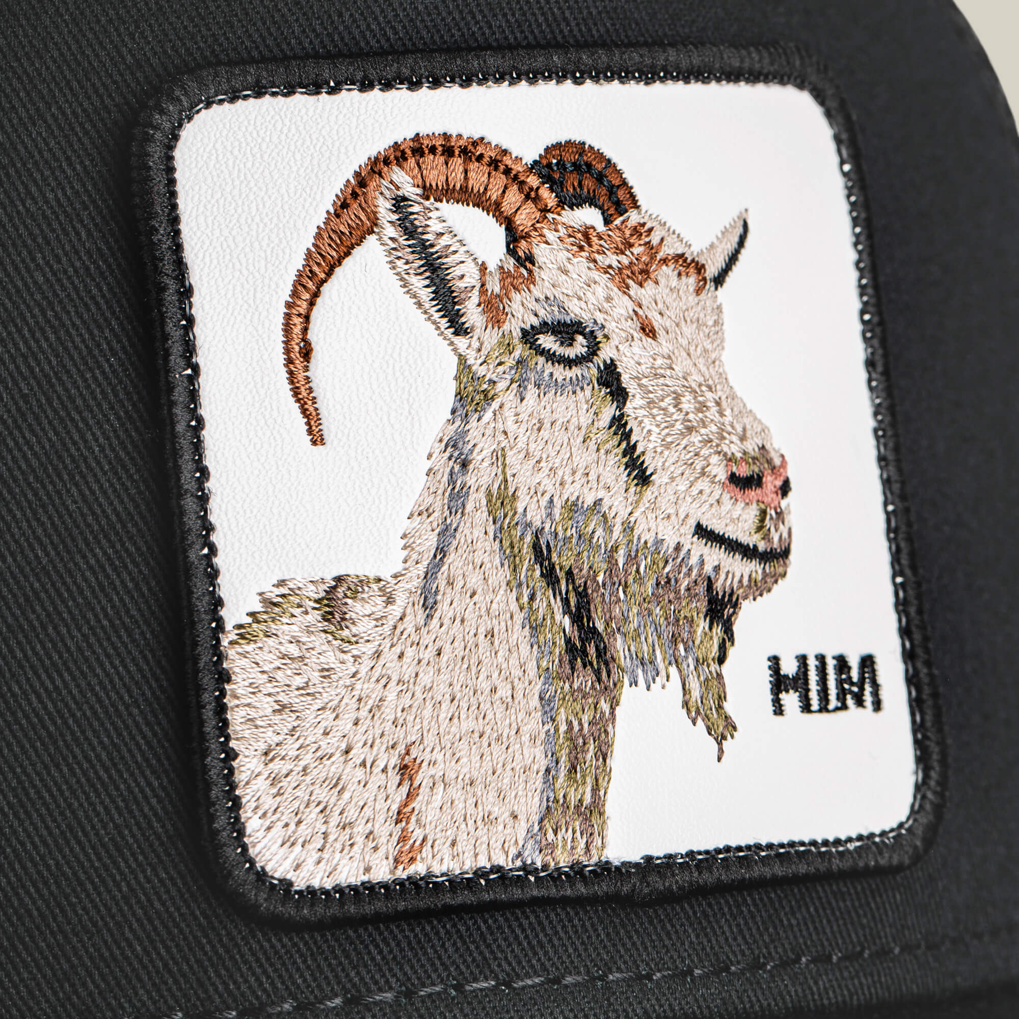 Embroidered patch of a Mirage HIM goat’s head with “MIM” text on black fabric—by Goorin Bros.—perfect for bold, standout apparel.