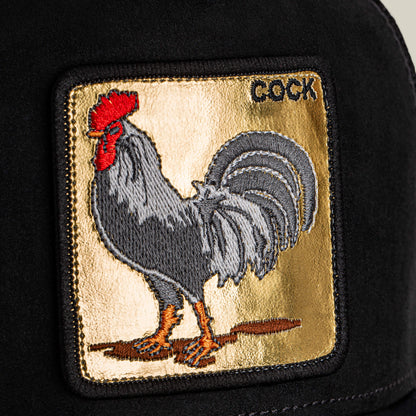 The Goorin Bros. "Golden Cock" patch features an embroidered rooster and golden lettering on a black fabric surface.