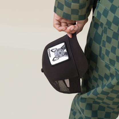 A person in a green checkered outfit holds The Frenchie Dog cap by Goorin Bros.—a black mesh small-dog hat featuring a patch with a dog’s face and the text FRENCHIE.