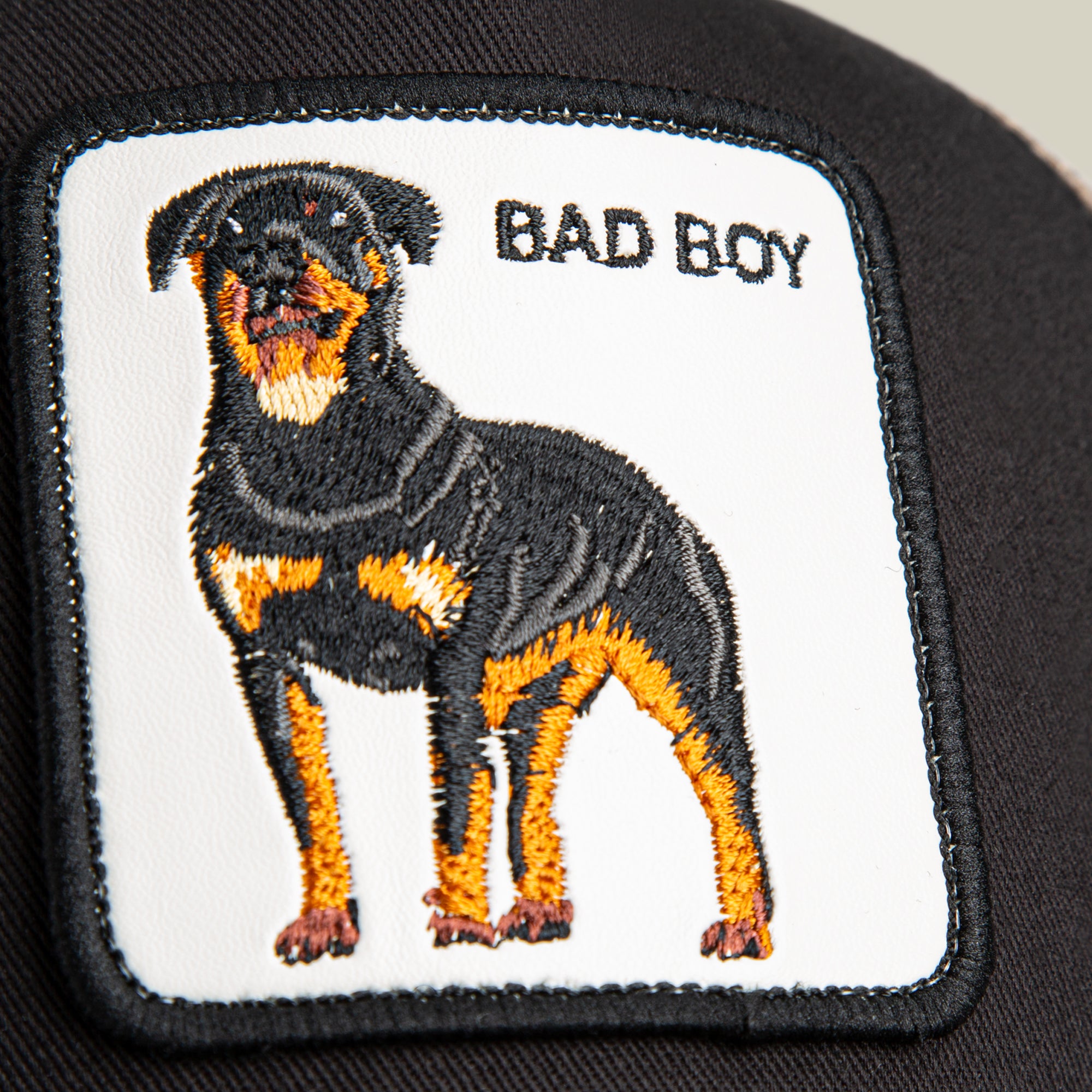 The Bad Boy patch by Goorin Bros. features an embroidered Rottweiler and "BAD BOY" on a dark background, creating a bold statement accessory for any stylish hat.