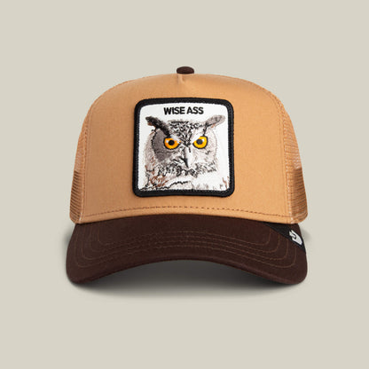The Wise Ass Trucker by Goorin Bros. is a tan and brown owl cap featuring a witty patch with an owl and the text "WISE ASS" above the image.