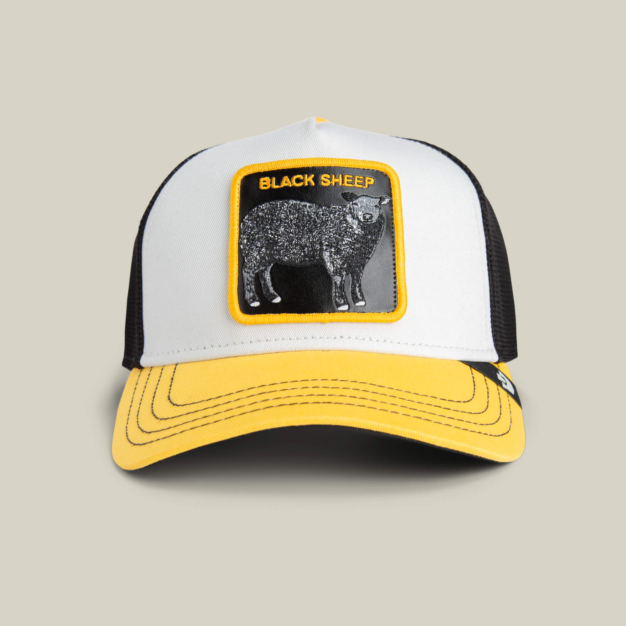 The Goorin Bros. Tricolor Sheep hat features bold black mesh, a white and yellow front, and a standout BLACK SHEEP patch with a black sheep design.