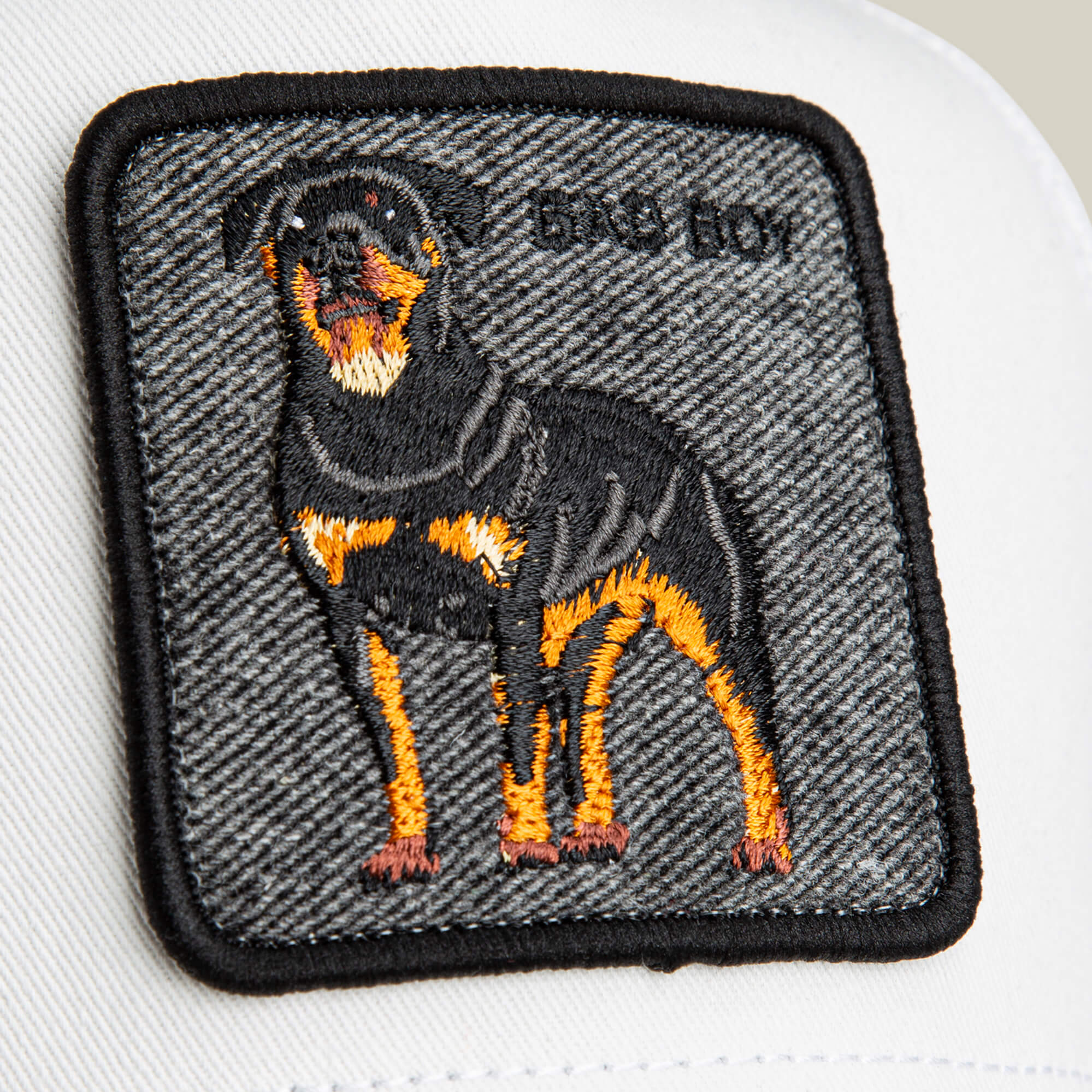 A close-up of the Goorin Bros. "Denim Bad Boy" patch shows a finely embroidered Rottweiler and the words BIG DOG—perfect for adding bold style to your clean whites.