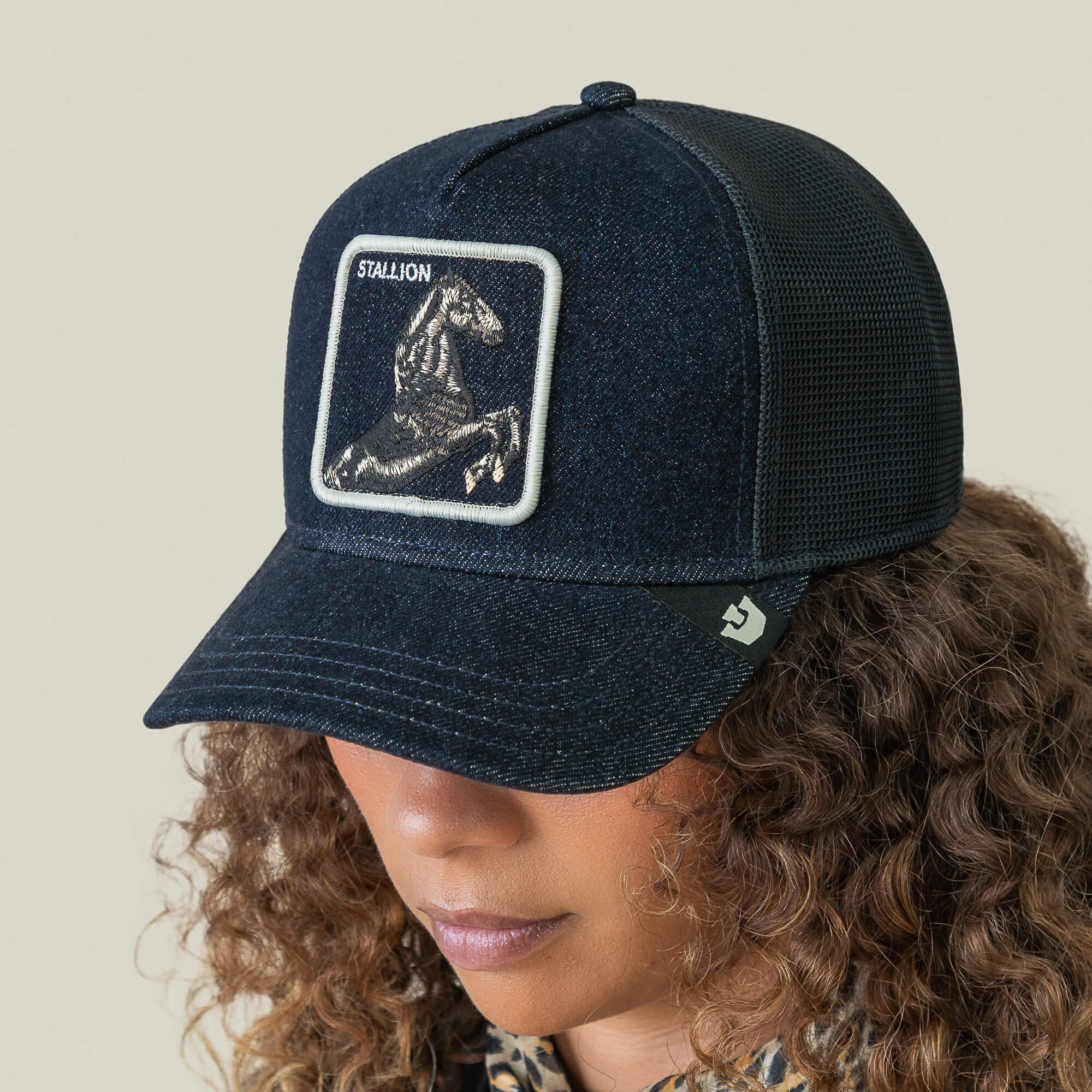 Model wearing the Goorin Bros. Denim Stallion cap, featuring an arena-style embroidered design with a Stallion horse patch on the front, displayed from a front angle against a neutral background.