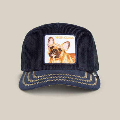 The Goorin Bros. High Class Remix cap is a navy blue corduroy hat with rich textures, a French bulldog patch labeled HIGH CLASS, and decorative brim stitching.