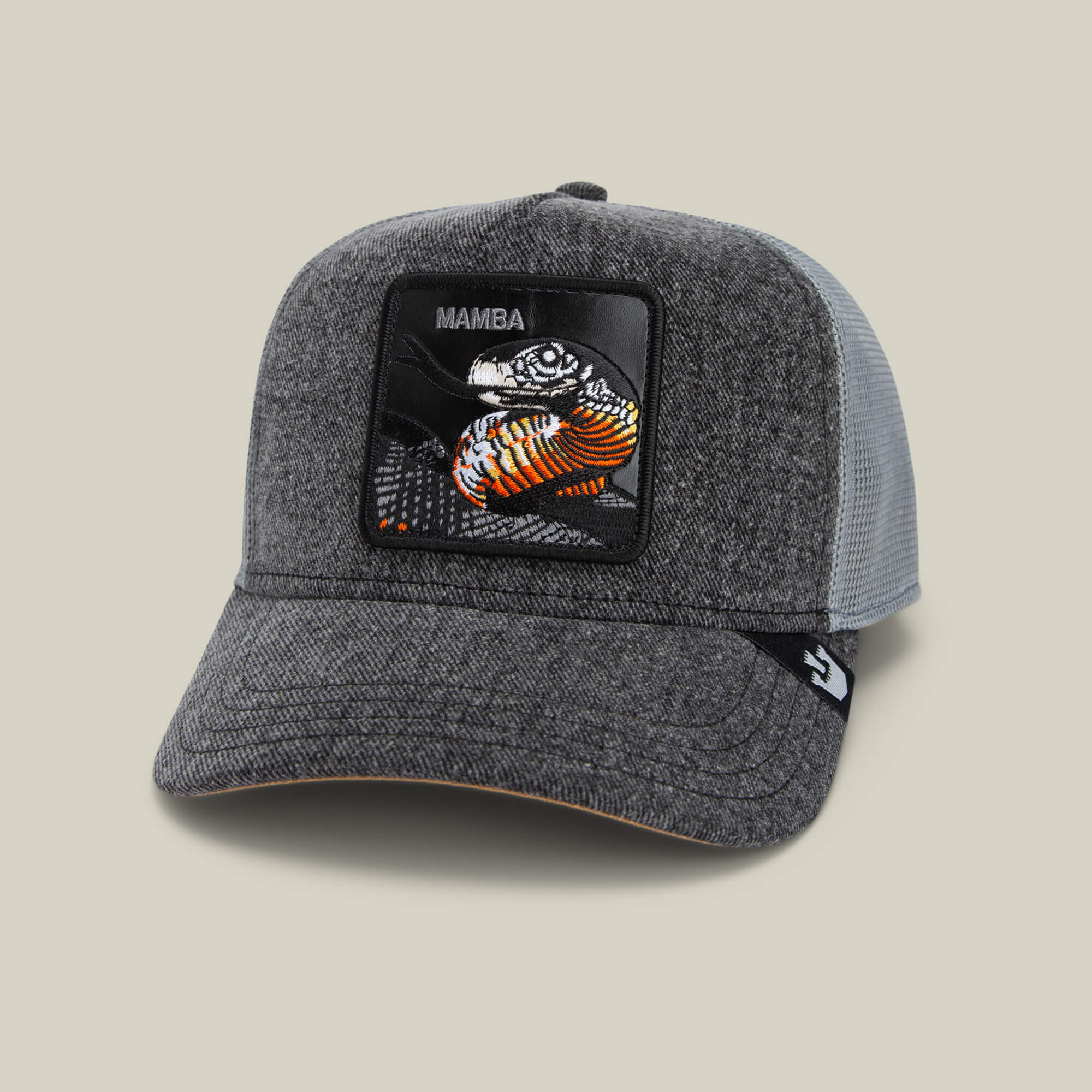 The Mamba by Goorin Bros. is a gray trucker hat with a mesh back and a vibrant embroidered mamba snake patch on the front, capturing the bold, predator mindset of this patient hunter.