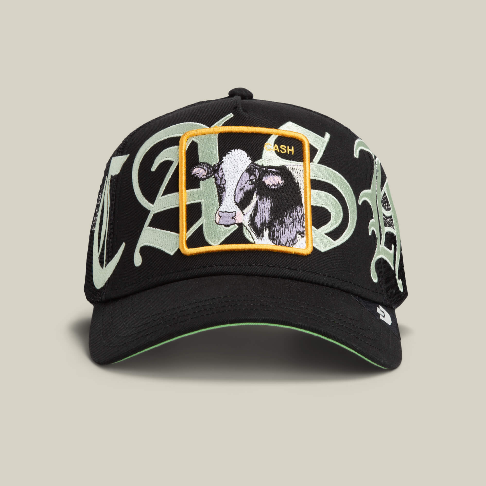 The Goorin Bros. Old English Cash cap in VOID features large light green Old English script and a rectangular patch with cow and goat illustrations, labeled CASH.