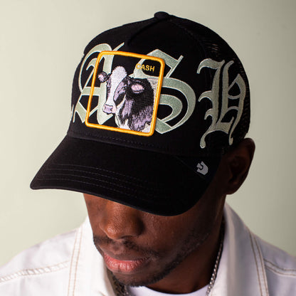 Someone wears the Goorin Bros. "Old English Cash" black cap, featuring Old English script and a yellow square patch with an illustrated goat.