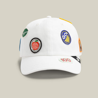 The Goorin Bros. Pop Appeal cap in DUST features colorful embroidered patches on the front and sides, shown against a beige background.