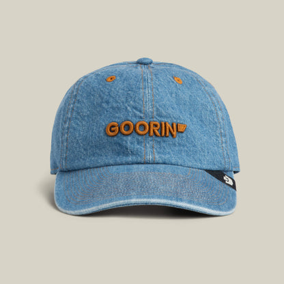The Papa Core Denim hat by Goorin Bros. features a sky blue denim finish and an orange embroidered GOORIN wordmark on the front, shown against a plain background.