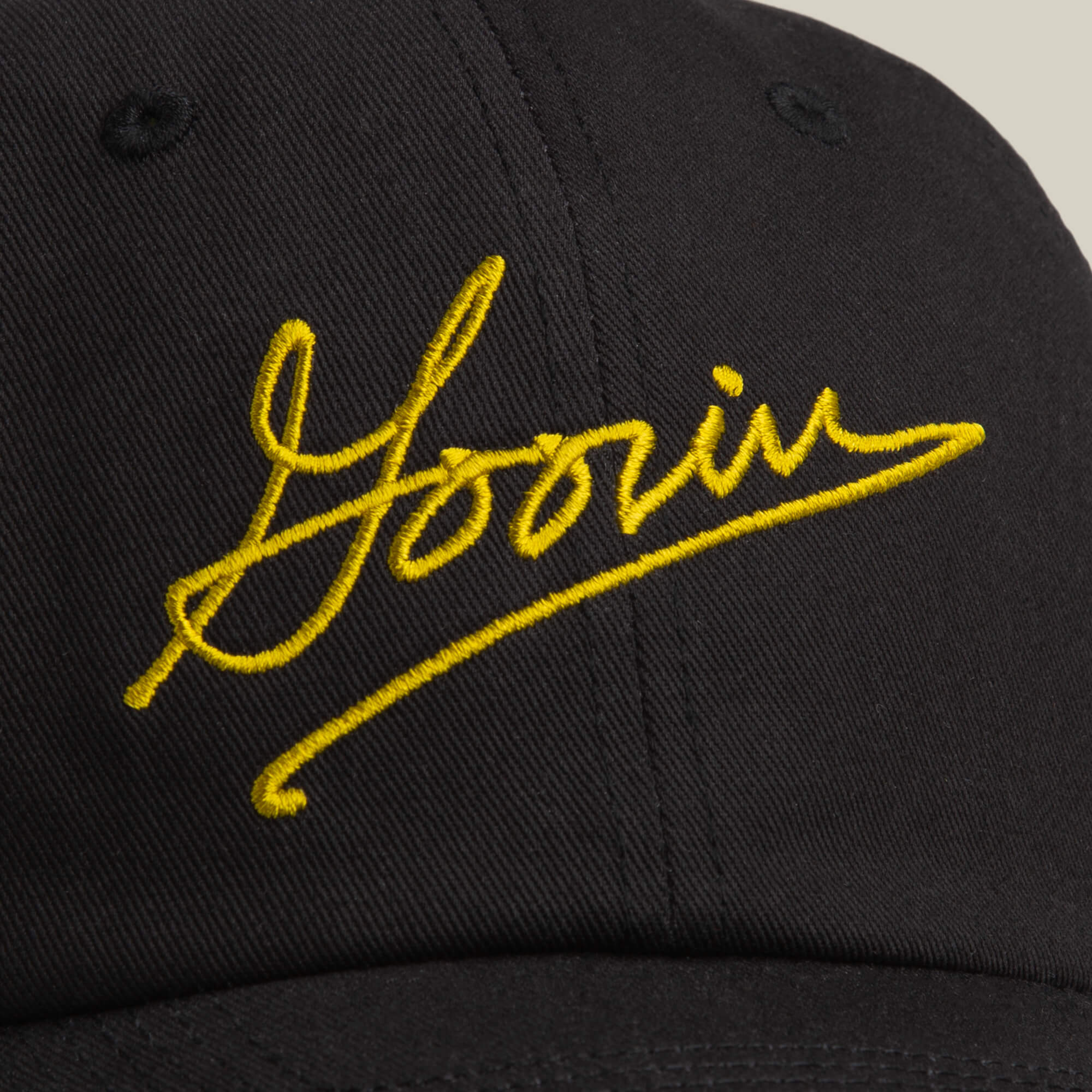 Close-up of the black Goorin Script Baseball cap by Goorin Bros. featuring "Yoorin" embroidered in yellow Goorin script on the front.