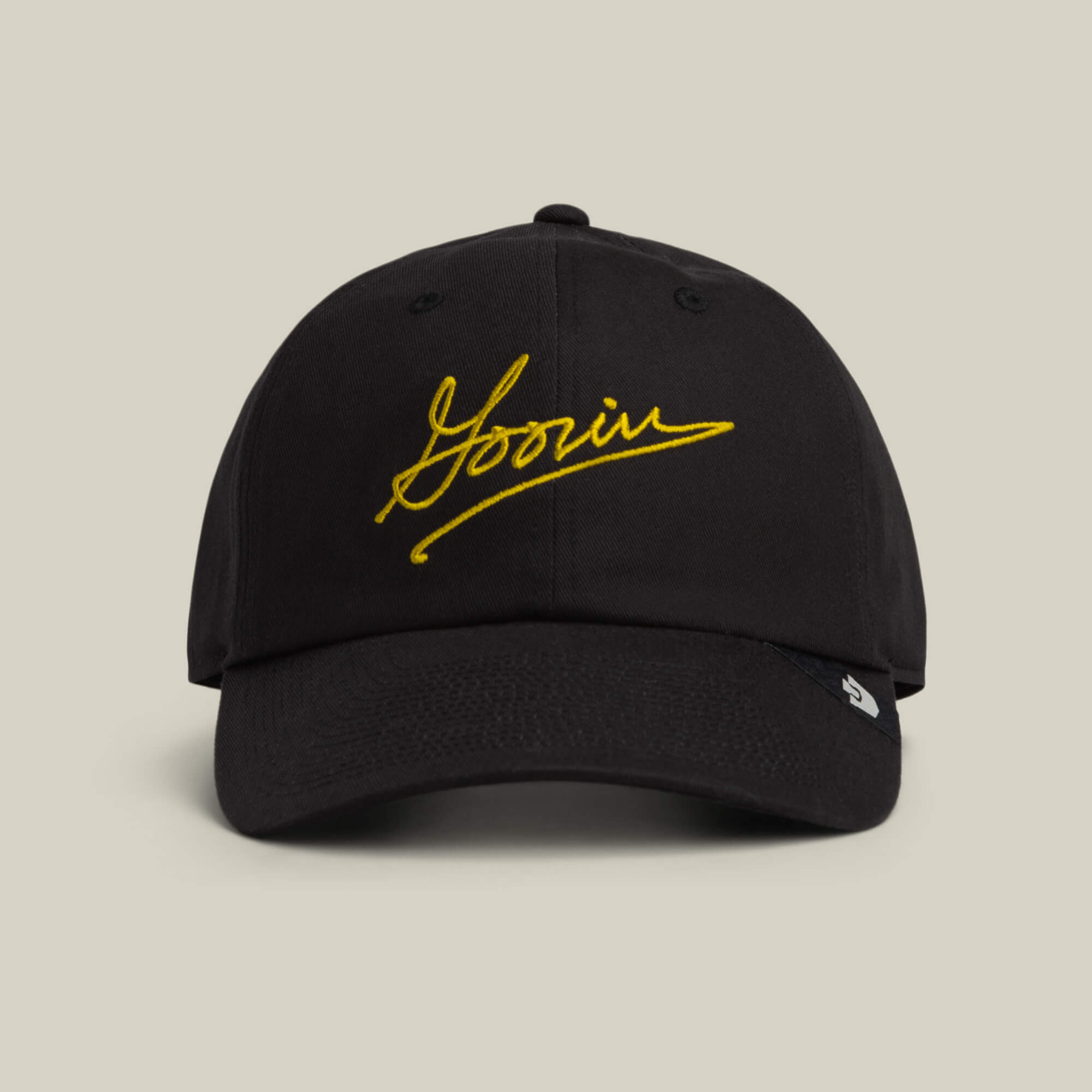 The Goorin Bros. Goorin Script Baseball cap in VOID features yellow cursive embroidery on the front, shown against a plain beige background.