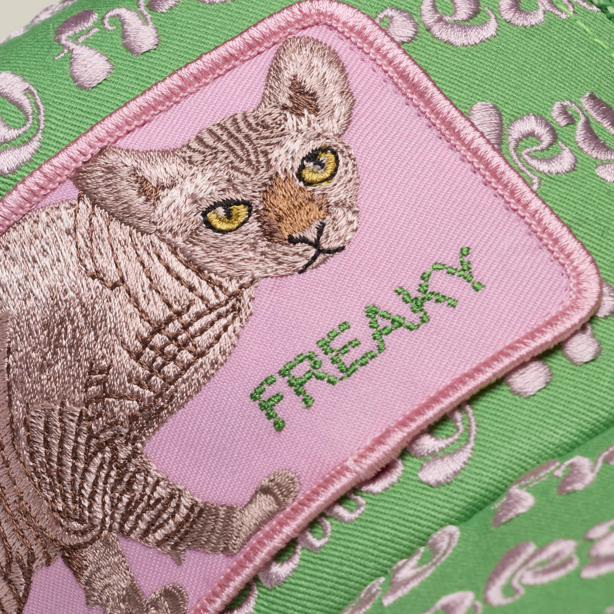 The Freaky Friday patch by Goorin Bros. features a cat and "FREAKY" embroidered on green fabric with light pink patterns—a bold accessory for those who embrace their wild side. The pink background adds to its quirky appeal.