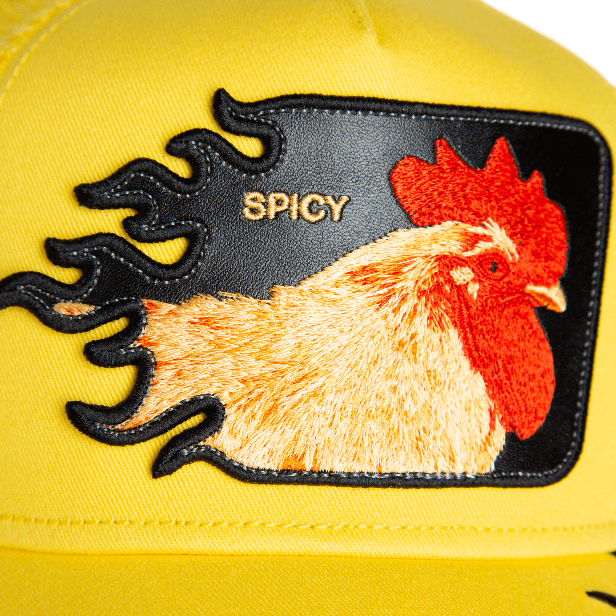 Close-up of the Goorin Bros. “Spicy Flames” trucker hat, showcasing an embroidered rooster patch, bold spicy flames, and "SPICY" in gold text.