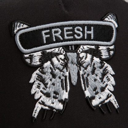 Close-up of the Goorin Bros. Classic Rocker - Fresh patch: a moth with outspread wings on black fabric, "FRESH" stitched above—great for adding edge to your night mode outfit or black mesh hat.