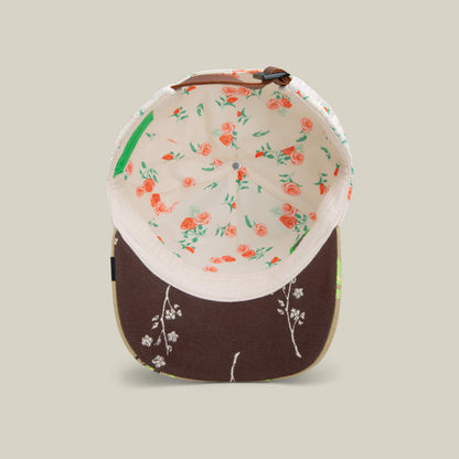 The Vol. 1 - Quiltbag: Live bucket hat by Goorin Bros. is shown from above, featuring a floral pattern with orange roses inside and delicate white floral embroidery on the brown brim.