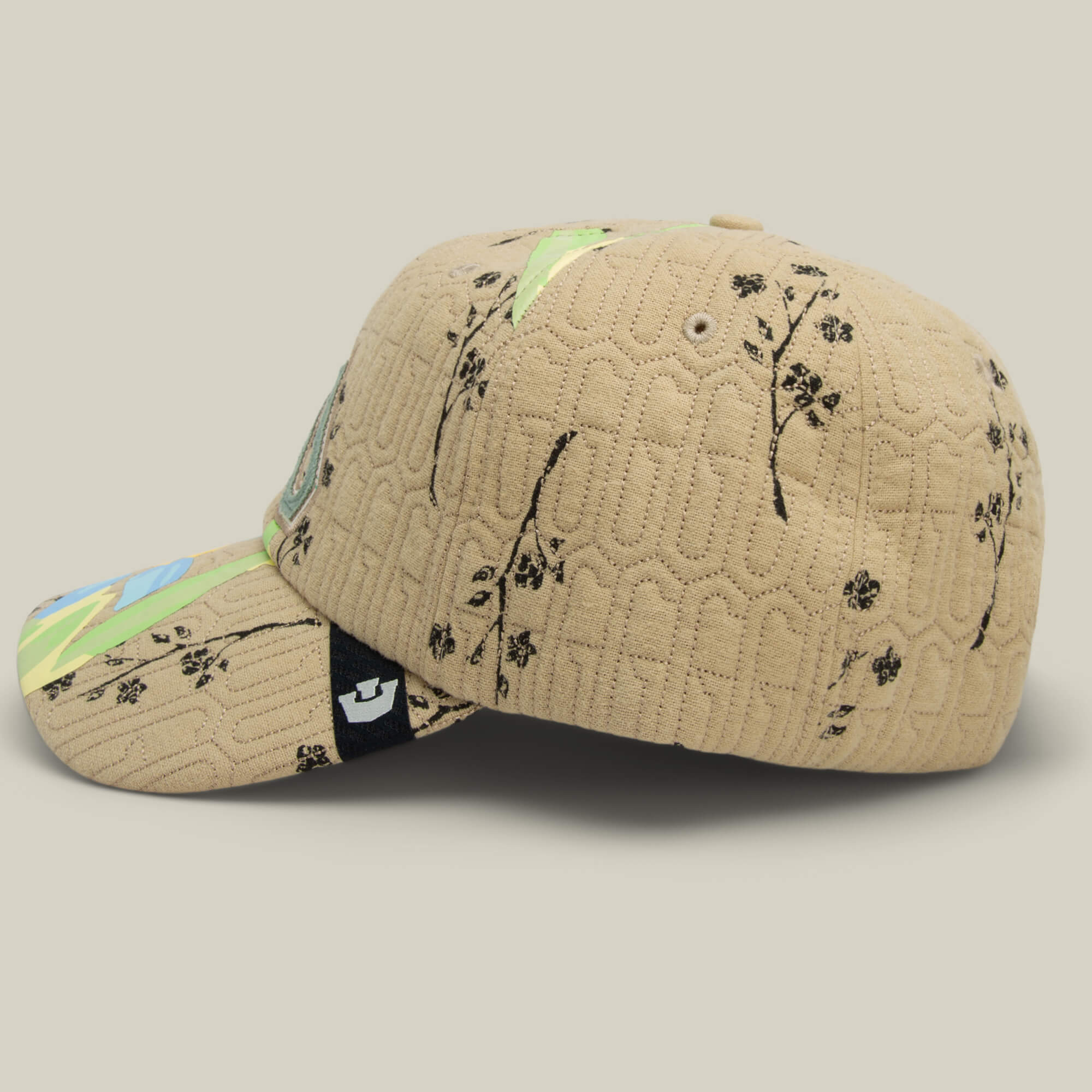 The Vol. 1 - Quiltbag: G Papa cap by Goorin Bros. features a tan quilted design with black floral patterns, a multicolored brim, and a black adjustable strap—perfect for adding flair to your casual style.