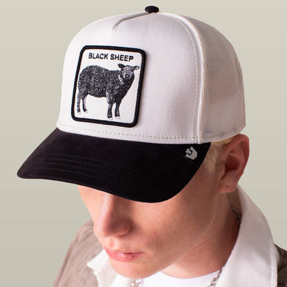 Someone wears the Suede Sheep hat by Goorin Bros.—a black and white cap with a suede brim, featuring a patch of a black sheep and the words “BLACK SHEEP.”.