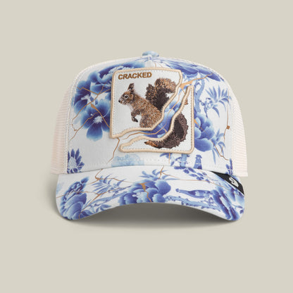 The Break The Mold hat by Goorin Bros. in CHALK features a blue floral pattern, white mesh back, and a front patch with a squirrel and "CRACKED"—a standout accessory for expressing your unique style.