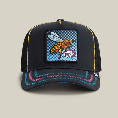 The Goorin Bros. Oh Bee Hive hat in VOID color features black mesh, a pop-art bee patch with "Buzz!", colorful brim stitching, and yellow crown accents.