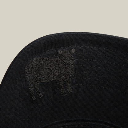 A close-up of the Goorin Bros. "Define Yourself - Black Sheep" low profile cap, showcasing an embroidered sheep outline on the brim against a plain, light background.