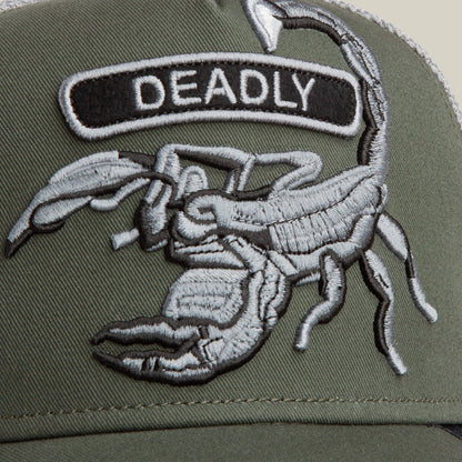 A close-up of the Goorin Bros. Classic Rocker - Deadly hat in military green, showcasing its scorpion patch and grey mesh detailing in the background.