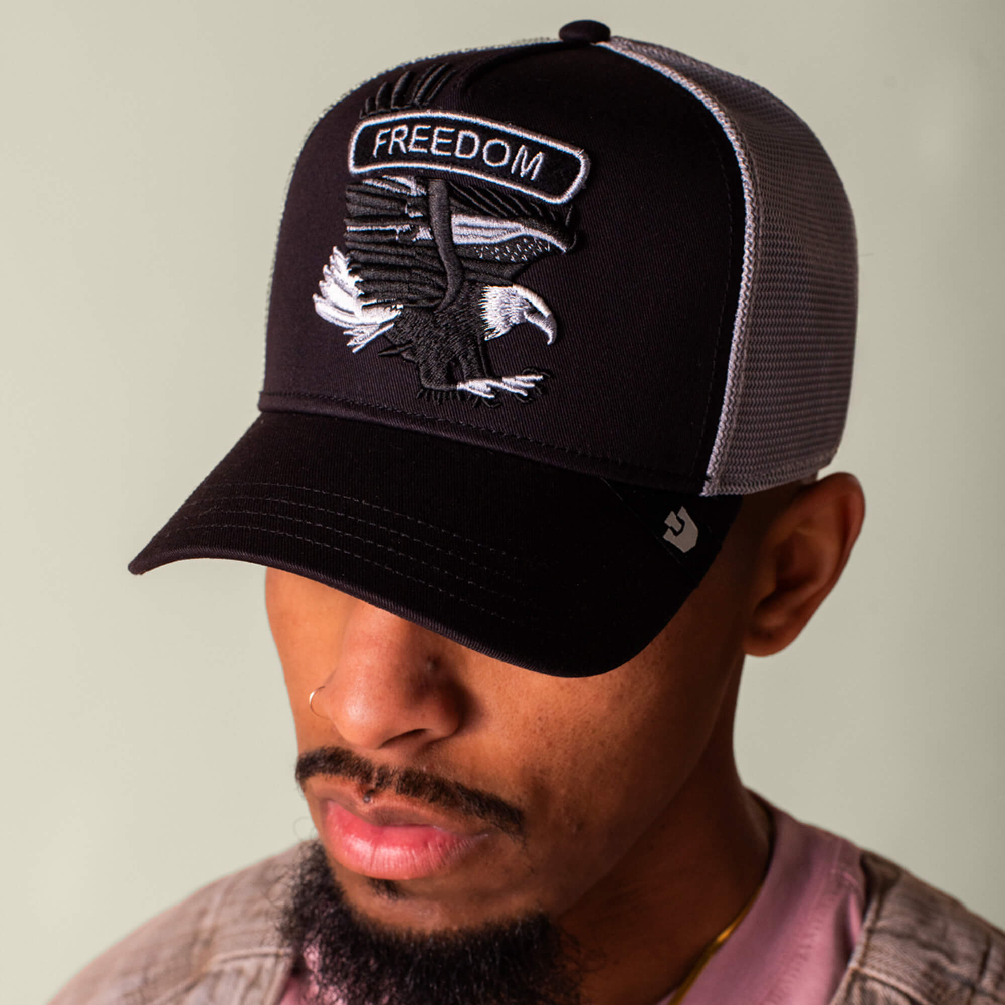 The Classic Rocker - Freedom by Goorin Bros. features a black mesh trucker hat with an embroidered eagle patch and "FREEDOM" on the front.