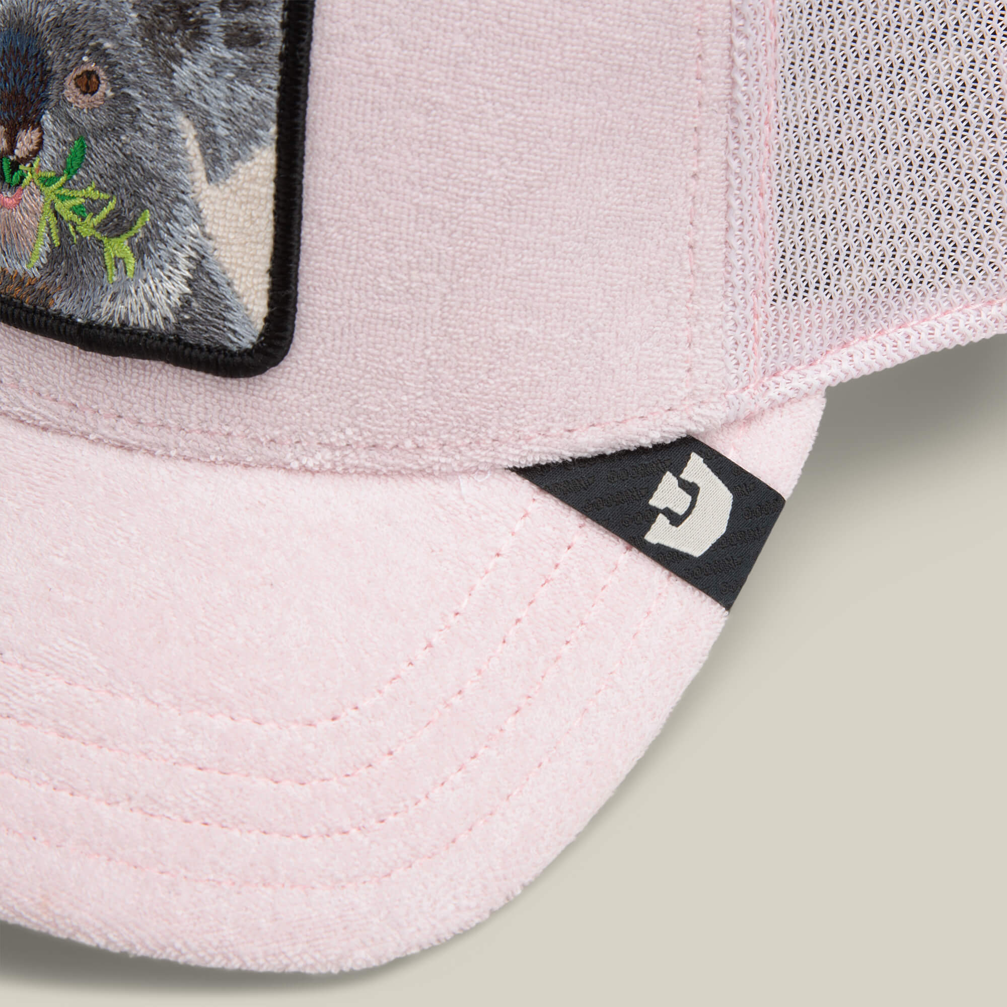 Close-up of the Goorin Bros. Terry Cloth Koala hat in pale pink, featuring a mesh back, a koala patch, and a small black tag with a white logo on the brim.