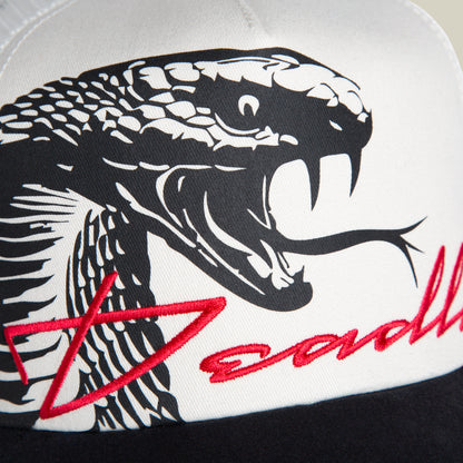 Close-up of the Goorin Bros. Outside the Lines Snake trucker hat in cream and black, featuring a black and white cobra illustration and partially visible red "Deadly" script on the front.