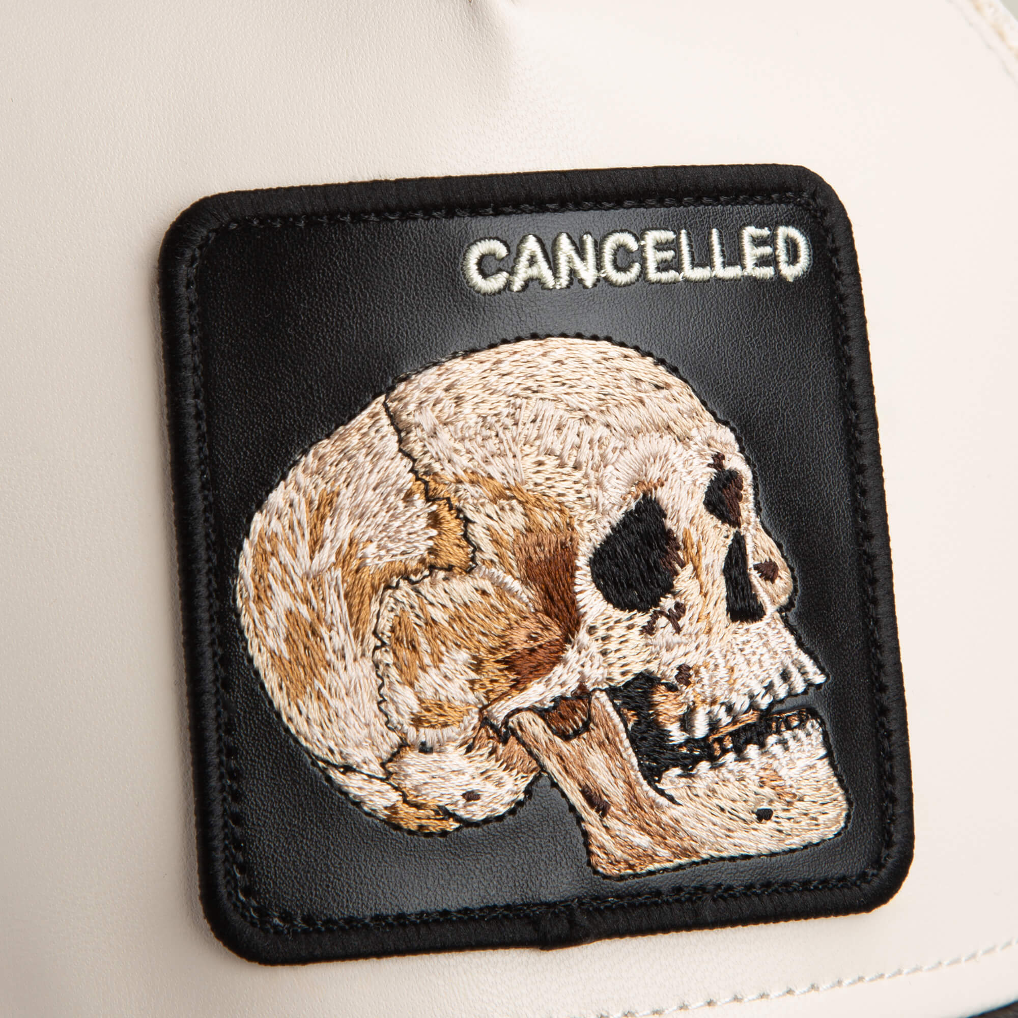 The Faux Leather Skull patch by Goorin Bros. features an embroidered human skull and the word "CANCELLED" on a neutral faux leather background.