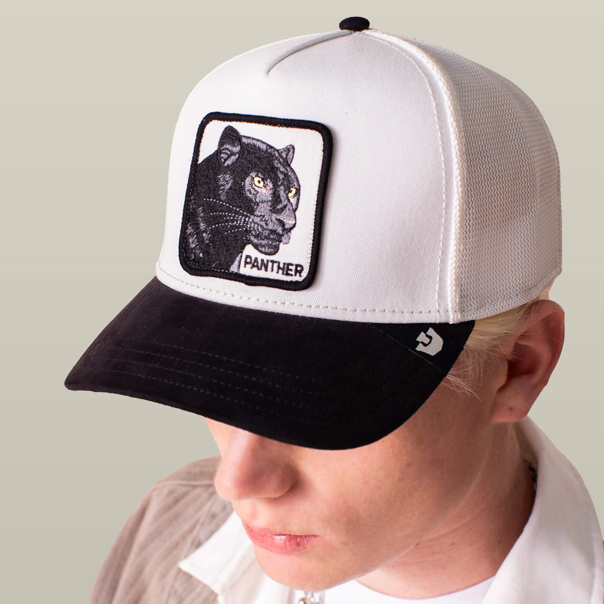 A person wears the Goorin Bros. Suede Black Panther cap—black and white with a microsuede brim and a front patch embroidered with a black panther and "PANTHER.