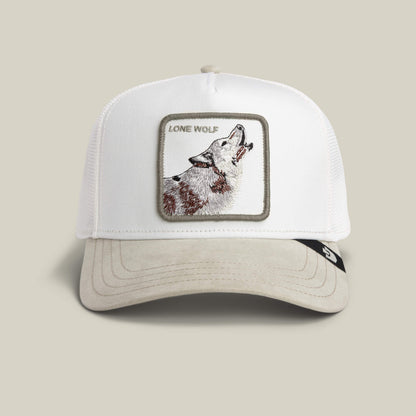 The Suede Wolf trucker hat by Goorin Bros. features a DUST white crown and SCOUT beige body with a rectangular patch of an embroidered howling wolf and "LONE WOLF" text on the front.