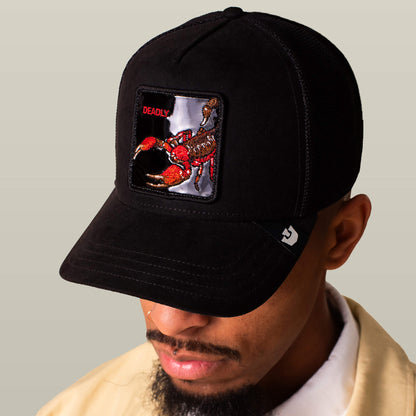 Man wearing the Goorin Bros. Black Out Scorpion cap in sleek black suede, featuring a bold scorpion patch and “DEADLY” embroidery.
