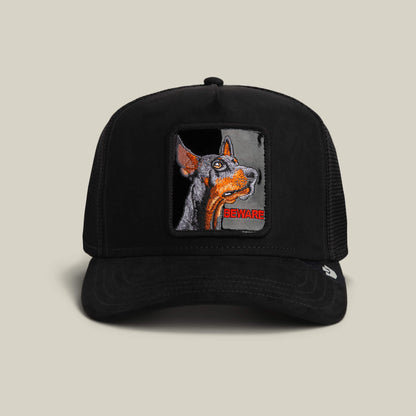 The Goorin Bros. Black Out Doberman trucker hat in VOID features a Doberman patch with "BEWARE" embroidered in red on the front.