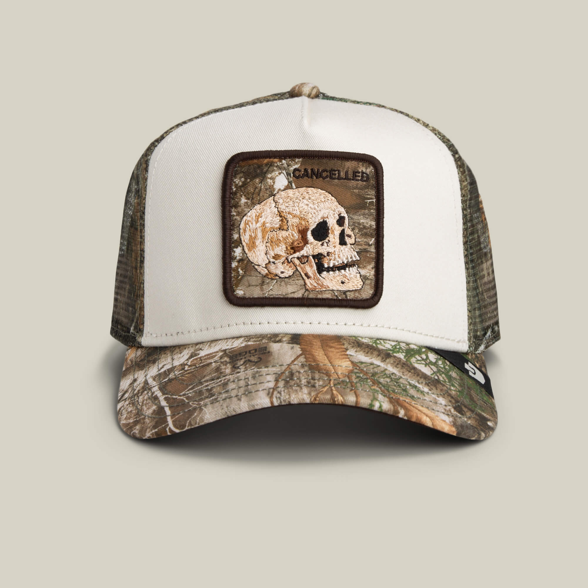 The Goorin Bros. Realtree Edge Cancelled Skull hat features a camouflage colorway, mesh back, and a bold skull patch with "CANCELLED" above it.