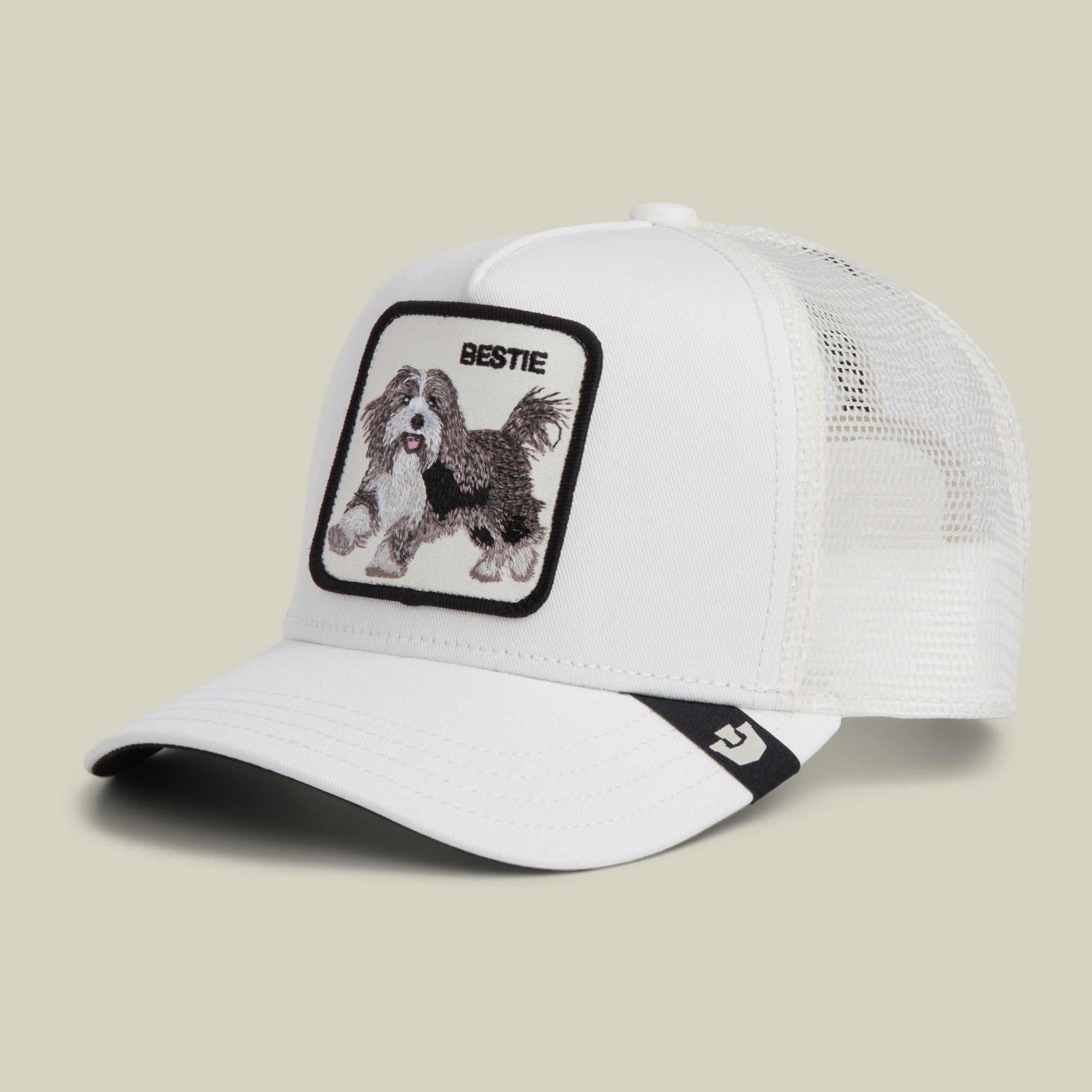 The Bestie Trucker by Goorin Bros. is a white mesh baseball cap featuring a front patch with an embroidered black and white dog and the word "BESTIE.