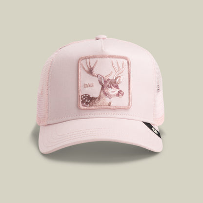 The Goorin Bros. Mirage Bae trucker hat in WHISPER features a light pink design with a mesh back and a front deer patch embroidered with "BAE.