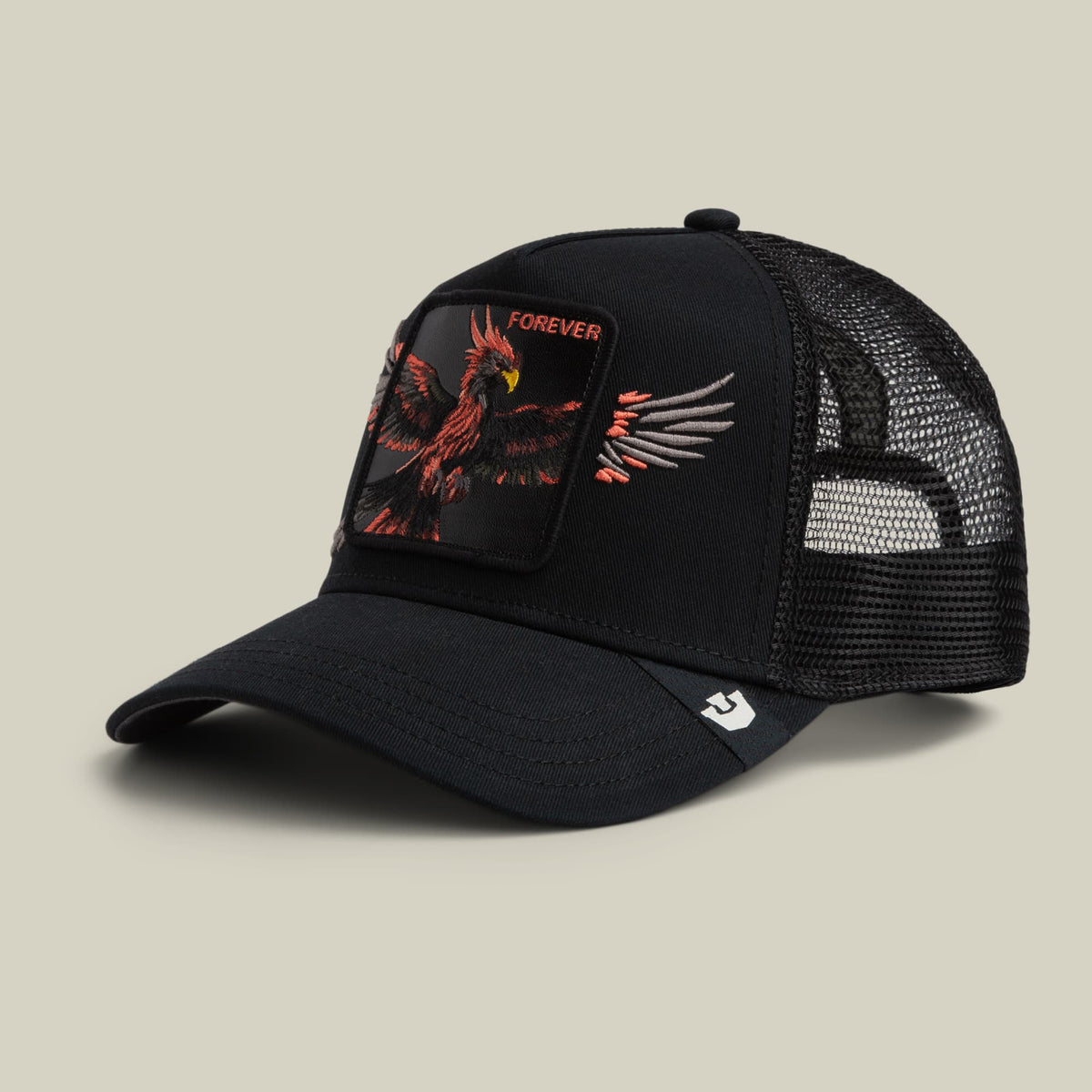 The Goorin Bros. Wings Forever trucker hat in black features red embroidered phoenix patch with "Forever" text on the front and mesh back panels, displayed against a neutral studio background.