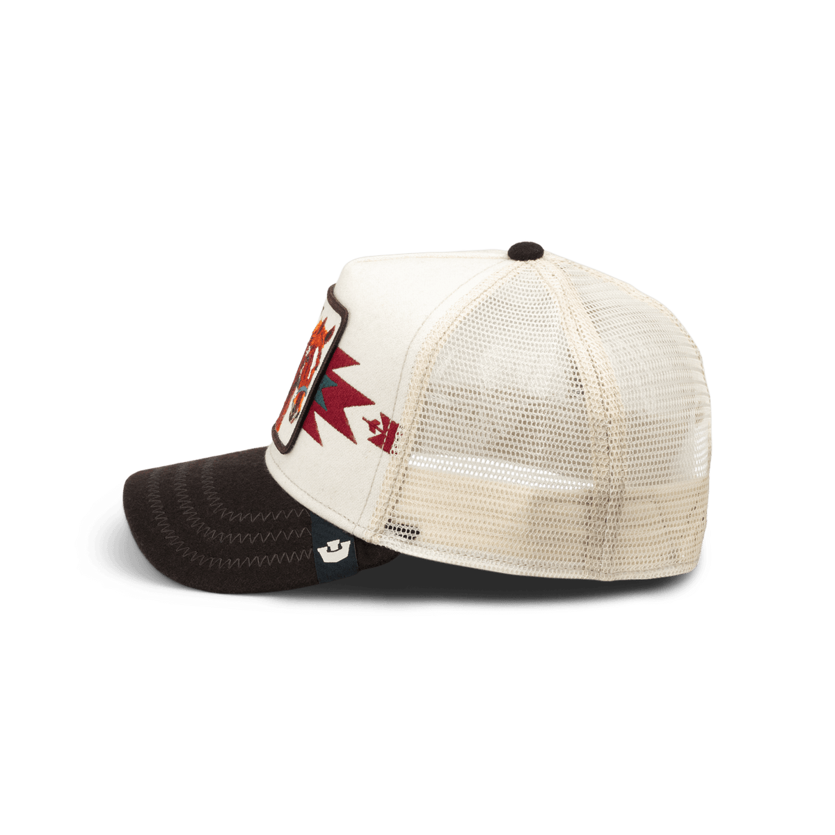 The Goorin Bros. Canyon Free Spirit trucker hat features a cream mesh back, white front panel, and black visor with burgundy and red embroidered branding, shown in a studio product shot from the side.