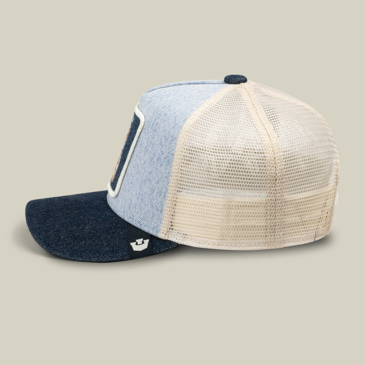 The Goorin Bros. Denim Cuddly trucker hat features a color-blocked design with light blue denim front, cream mesh back, and dark navy bill, displayed in a studio product shot.
