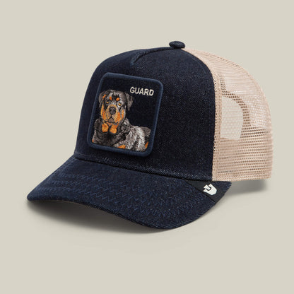 The Denim Guard by Goorin Bros. is a navy and beige trucker hat with a mesh back, featuring an embroidered Rottweiler patch and the word "GUARD" on the front.