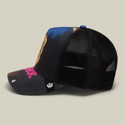 The Girl with the Pearl Necklace by Goorin Bros. is a black mesh trucker hat featuring a blue and gold patch on the crown and magenta logo embroidery on the bill, shown in a studio product shot from the side.