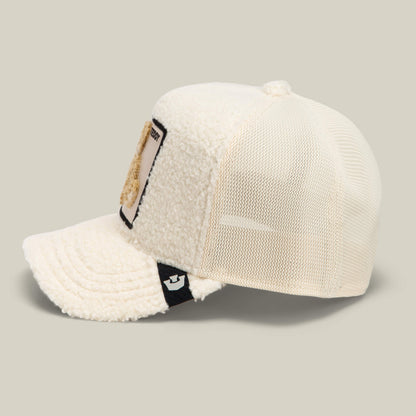 The Double Stuffed - Teddy by Goorin Bros. is a cream sherpa trucker hat featuring a mesh back, textured fleece front panel, a rectangular teddy patch on the front, and a small black tag on the side.
