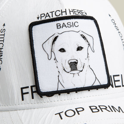 The K.I.S.S. cap by Goorin Bros. is a limited-edition white HDPE hat with black text and labels, featuring a square patch with a minimalist dog line drawing and "BASIC" above it—perfect for adding unique style to any outfit.