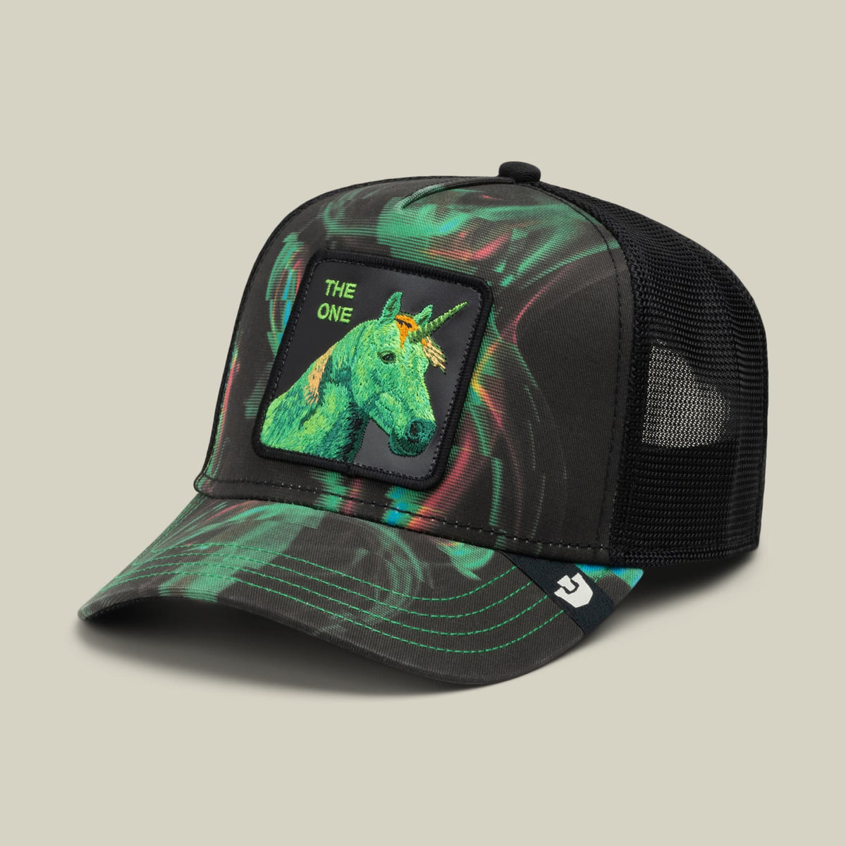 The No Spoon trucker hat by Goorin Bros features a neon green unicorn graphic with "THE ONE" text on a black mesh back panel, set against a vibrant multicolored swirl print base in black, green, and pink tones.
