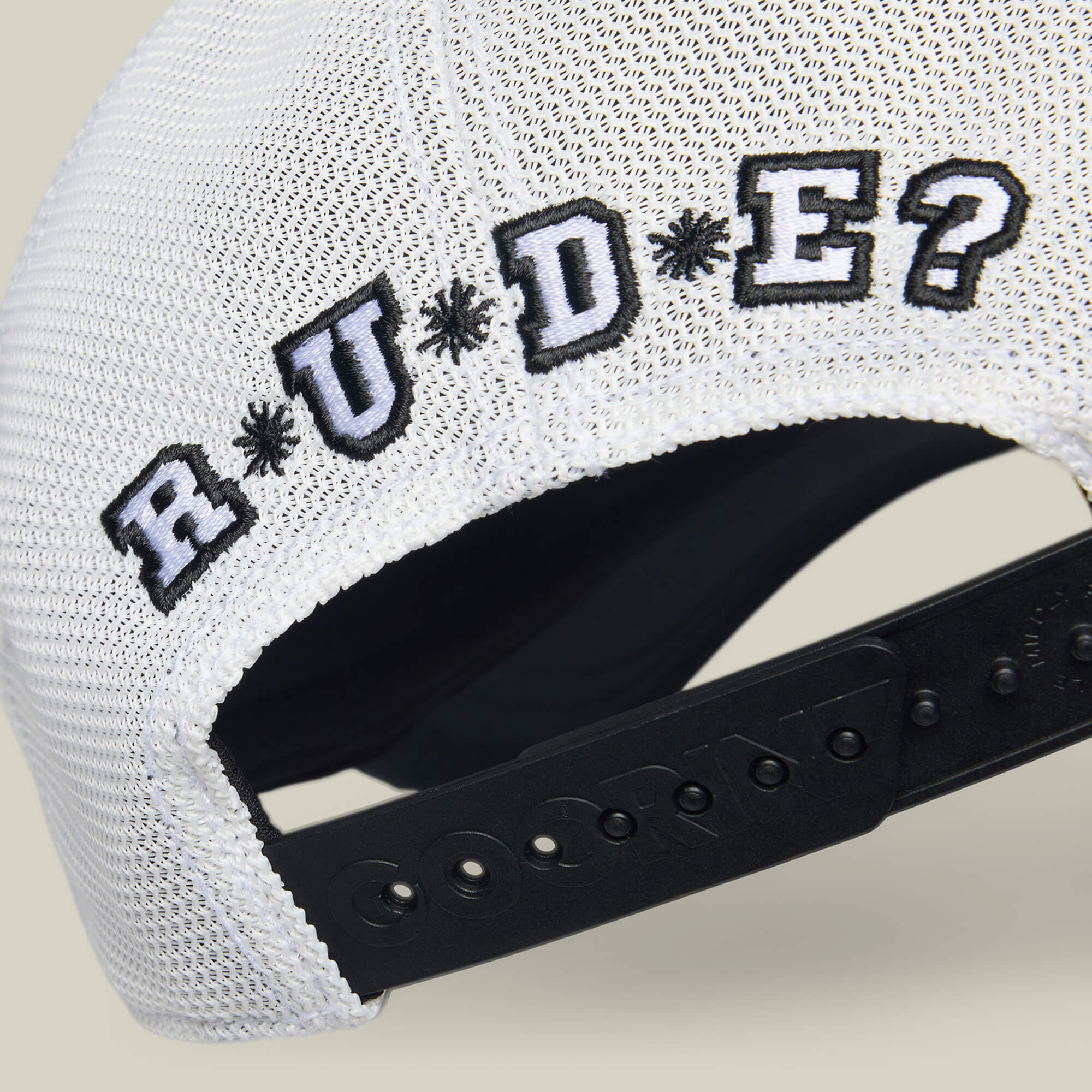 Close-up of the back of a white mesh baseball cap by Goorin Bros. with "R U Done Eating?" embroidered in black and white above the adjustable strap, challenging your vibe and manners.