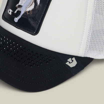 Close-up of the Goorin Bros. "R U Done Eating?" white trucker hat featuring a black brim, mesh side panel, animal patch on the front, and a small gray logo—ideal for adding a polite vibe to casual settings.